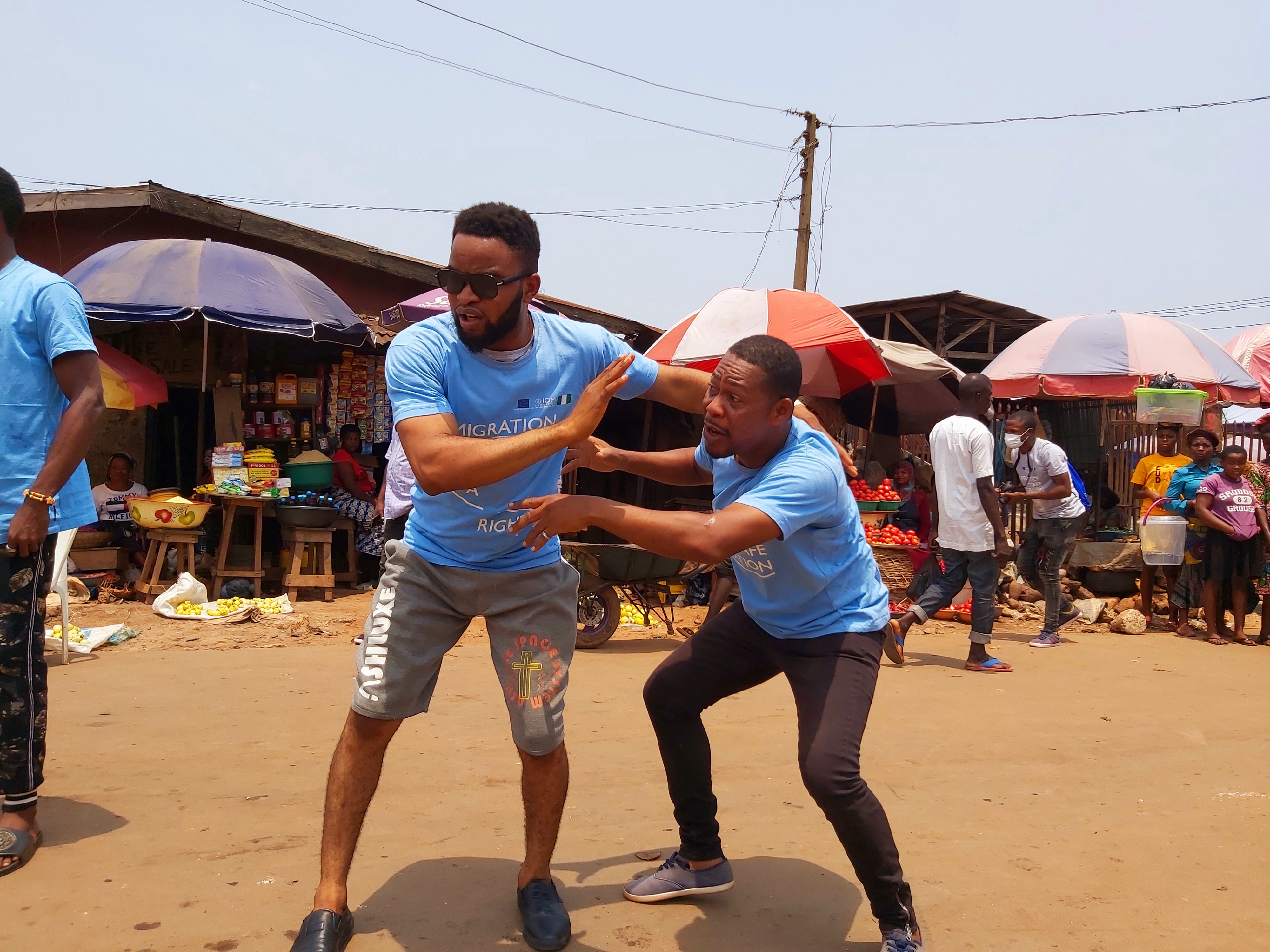 Clement acting during the community theatre play, ‘Dance of a migrant’ at a market in Benin city. © IOM 2021/Elijah Elaigwu