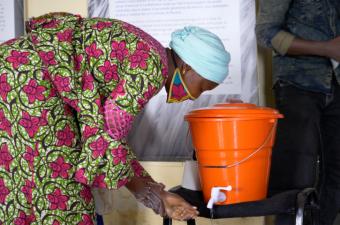 A participant uses the portable handwashing station.  