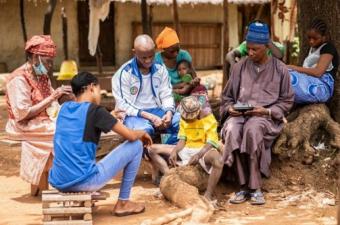 Une famille se retrouve autour de la radio dans la région de Kédougou pour suivre un programme sur la prévention de la Covid-19, © Sylvain Cherkaoui /IBM/ OIM Sénégal