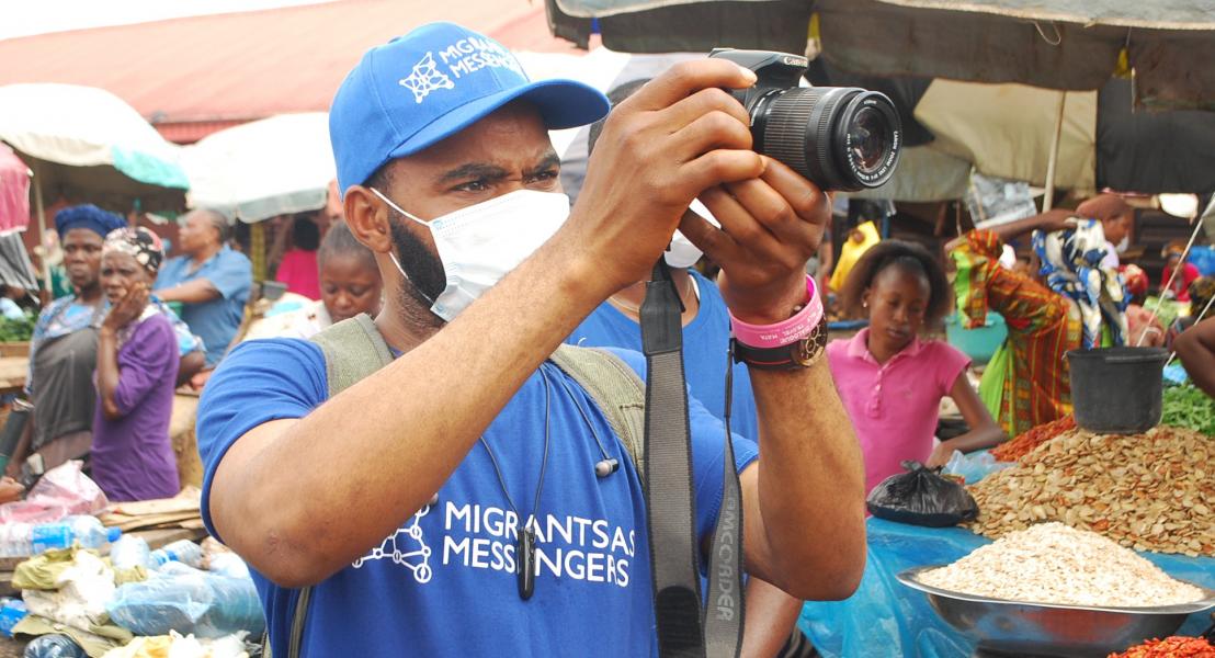 Clement recording videos during a market sensitization in Benin City ©IOM 2020/Elijah Elaigwu