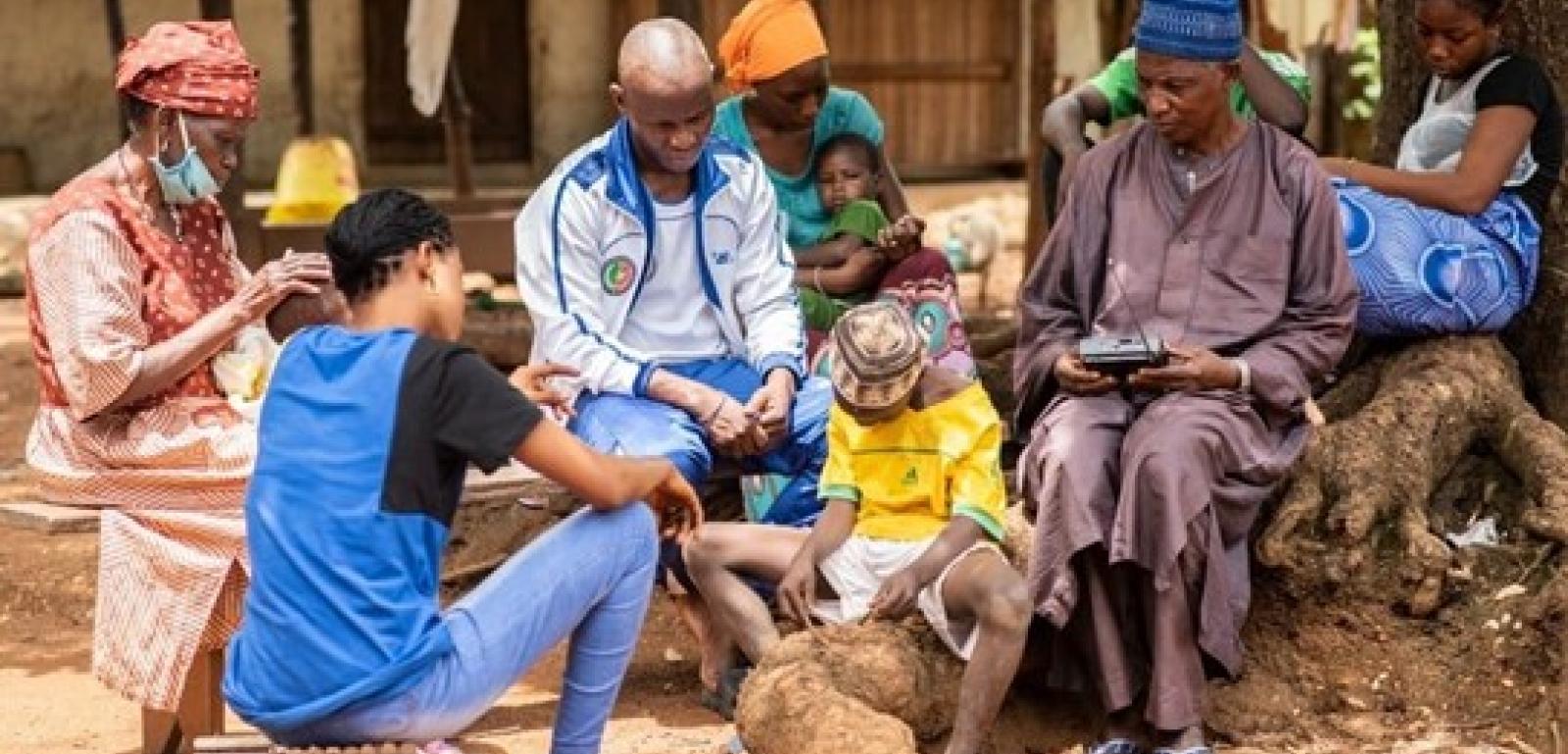 Une famille se retrouve autour de la radio dans la région de Kédougou pour suivre un programme sur la prévention de la Covid-19, © Sylvain Cherkaoui /IBM/ OIM Sénégal